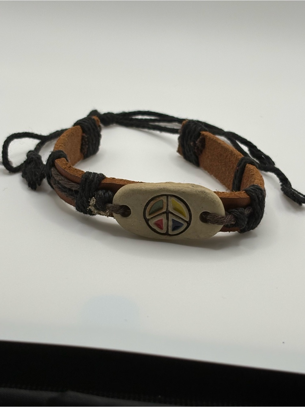 Brown leather black corded bracelet w painted peace symbol on center stone/rock